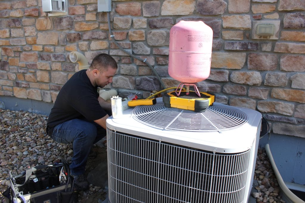 A The Weather Changers employee working outside on a ac unit.
